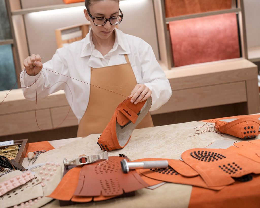 A Tod's frequentemente coloca seus artesãos em destaque: em sua loja, um artesão mostra como parte do mocassim Gommino, exclusivo da marca, é feito