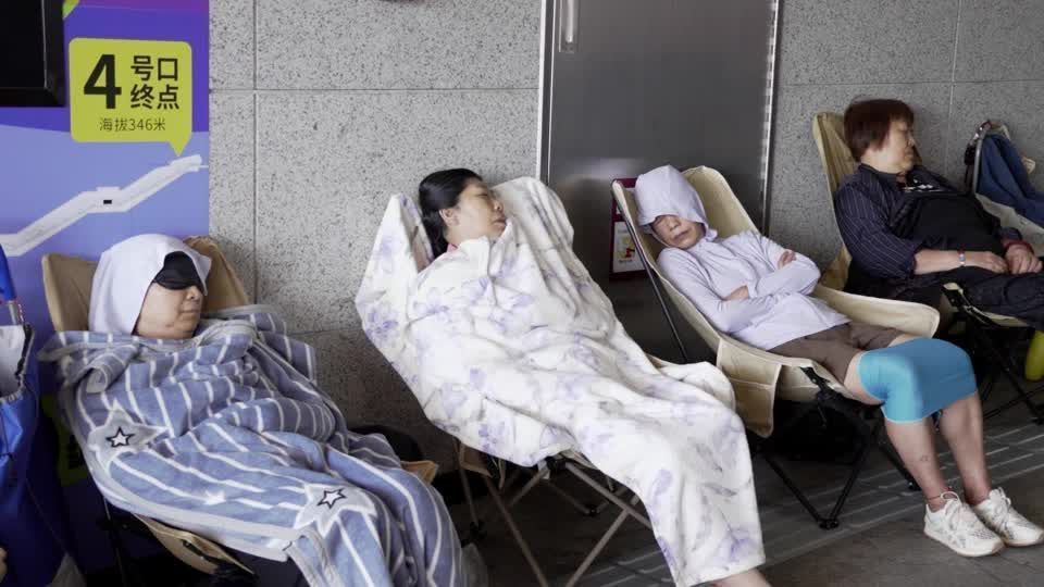 Moradores sentados em estação de metrô na China