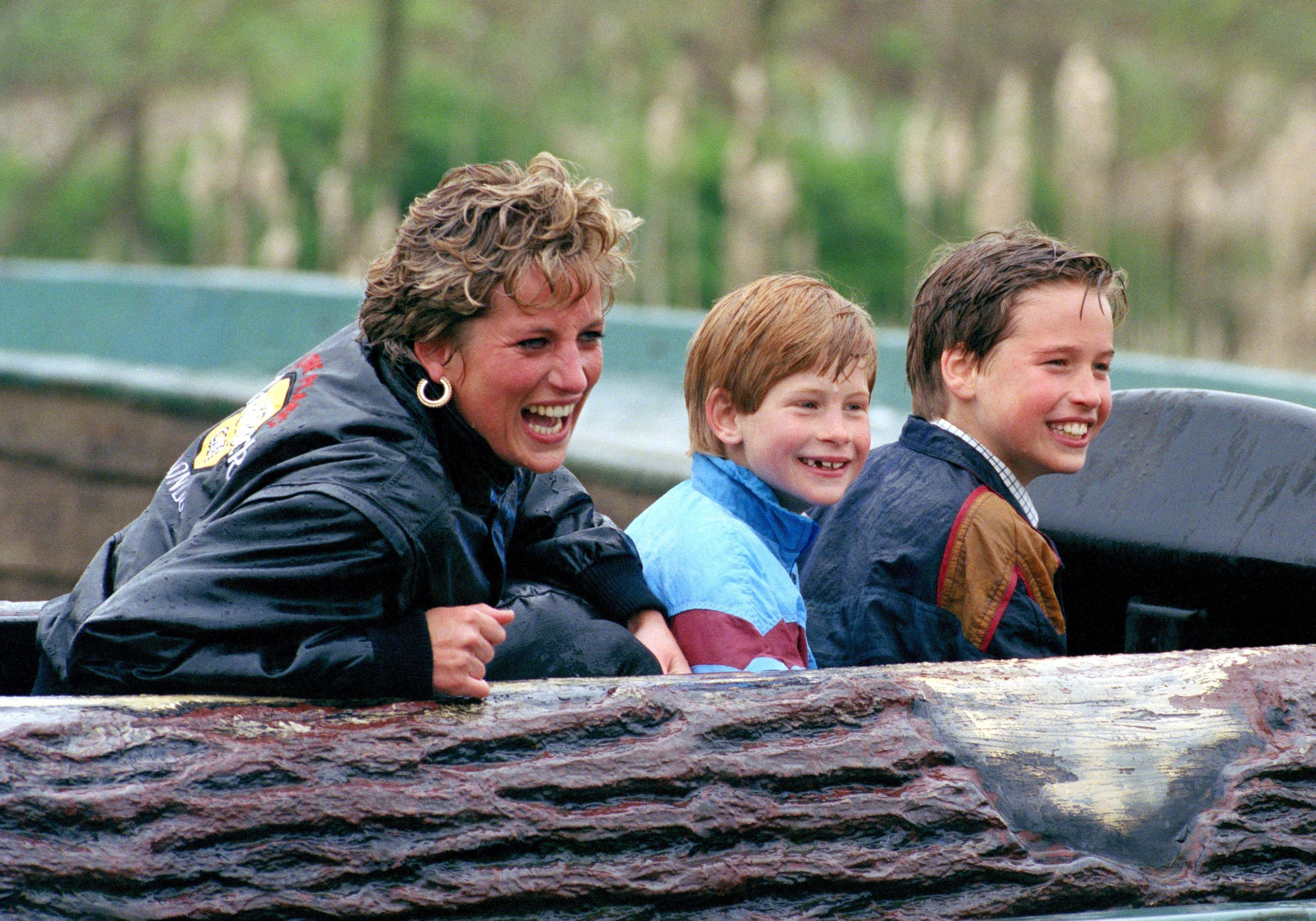 Diana, princesa de Gales, o príncipe William e o príncipe Harry visitam um parque de diversões • Julian Parker/UK Press via Getty Images