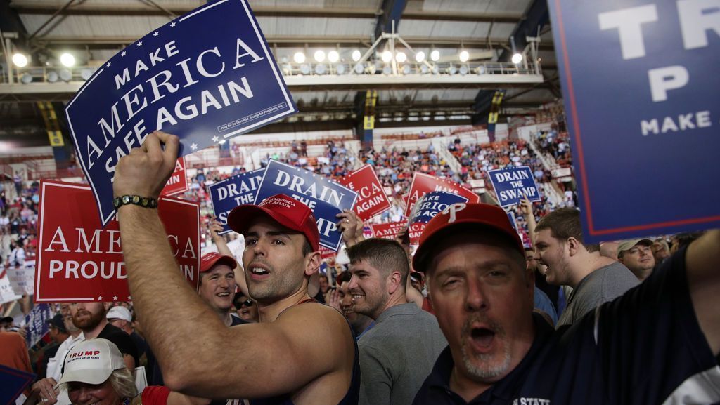 Apoiadores de Donald Trump seguram cartazes antes do "Make America Great Again Rally" (Comício Torne a América Grande Novamente) no Complexo de Exposições e Centro de Exposições da Pensilvânia, em 29 de abril de 2017, em Harrisburg, Pensilvânia