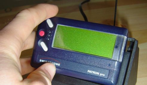 A fotografia mostra uma pessoa segurando um pager.