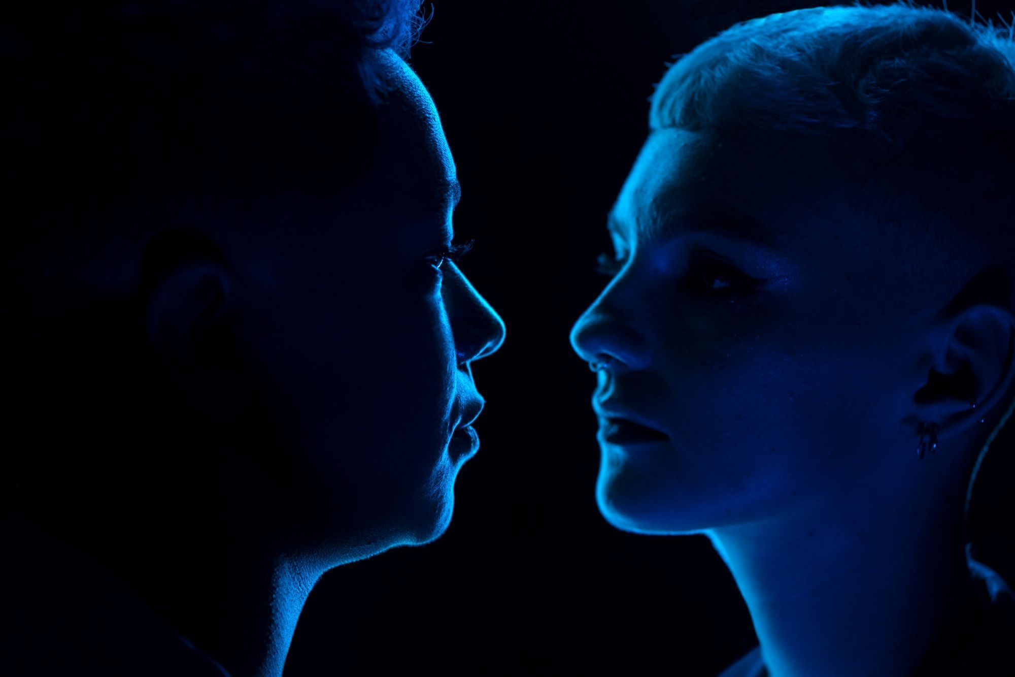 duas-pessoas-se-encarando-em-fundo-azul