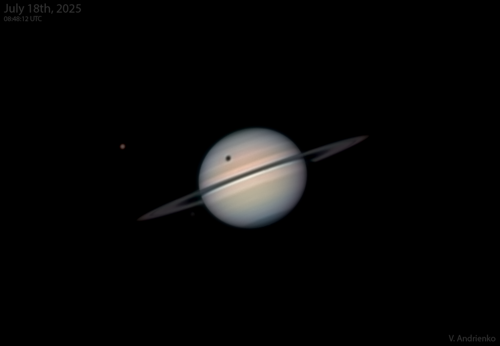 À esquerda, é possível ver Titã, a maior lua de Saturno, que projeta sua sombra na superfície do planeta, pouco acima dos anéis • Volodymyr Andrienko