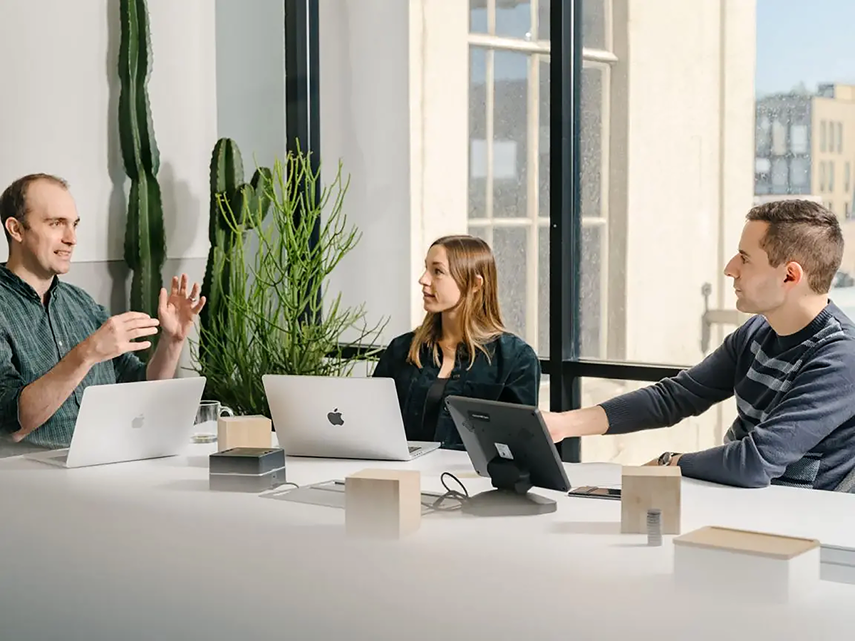 pessoas-reunidas-em-mesa-com-laptops