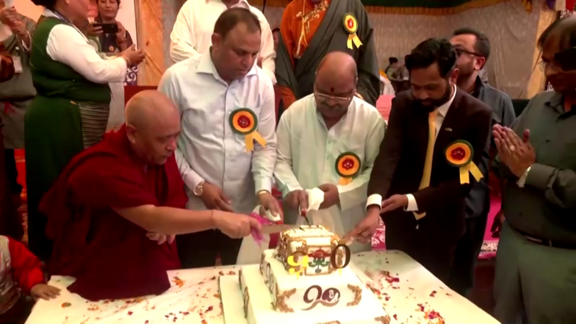 Monges cortando bolo em comemoração ao aniversário do Dalai Lama