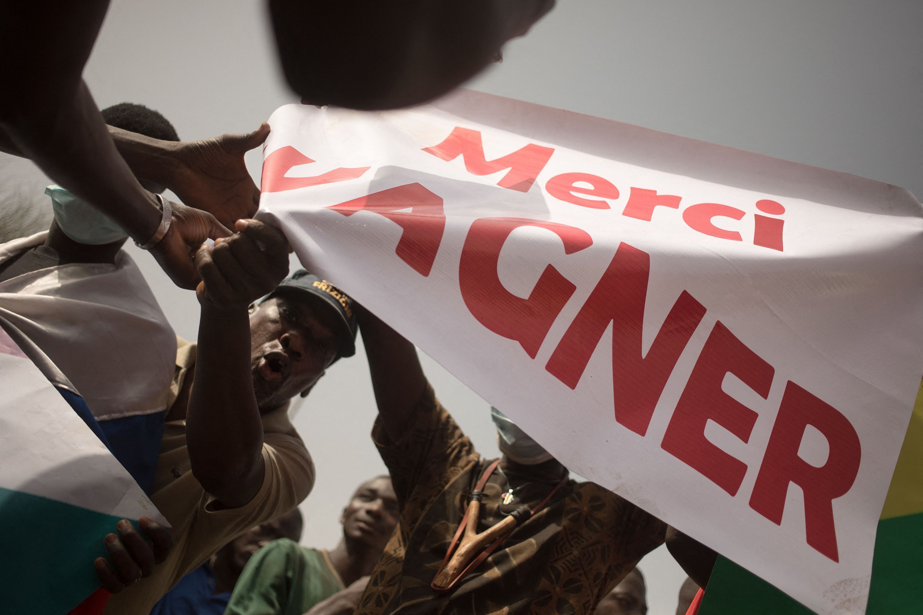 Manifestantes seguram uma faixa com os dizeres "Obrigado, Wagner" durante uma manifestação organizada para celebrar o anúncio da França de que retiraria as tropas francesas do Mali, em fevereiro de 2022 • Florent Vergnes/AFP/Getty Images via CNN Newsource