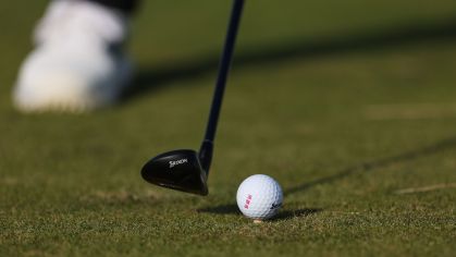 Taco indo em direção da bola de golfe