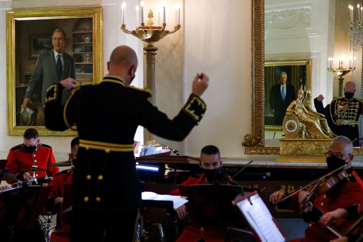 O retrato do ex-presidente George W. Bush na Casa Branca é visto à esquerda, enquanto membros da Banda da Marinha dos EUA tocam músicas natalinas durante uma turnê de imprensa pelas decorações de Natal da Casa Branca em novembro de 2021. • Jonathan Ernst/Reuters/File via CNN Newsource