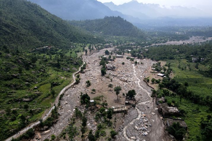 Vista aérea mostra casas parcialmente submersas em lodo ao longo do leito de um rio após enchentes repentinas no distrito de Buner, na província de Khyber Pakhtunkhwa • Abdul Majeed/AFP/Getty Images via CNN Newsource