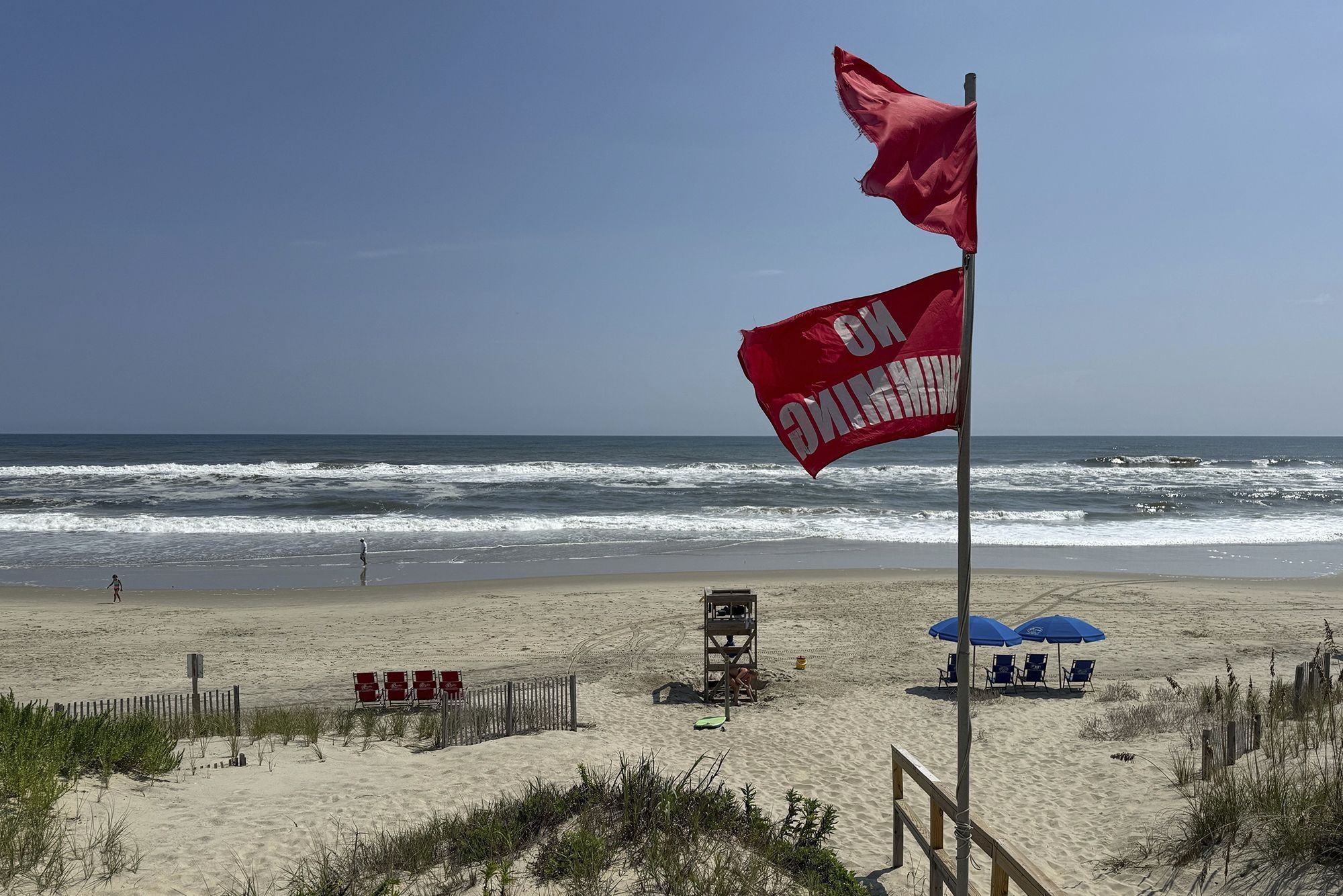 Bandeiras vermelhas, indicando que nadar é proibido, são hasteadas na praia em Duck, Carolina do Norte, em 19 de agosto, como precauções contra o furacão Erin • Pablo Martinez Monsivais/AP via CNN Newsource
