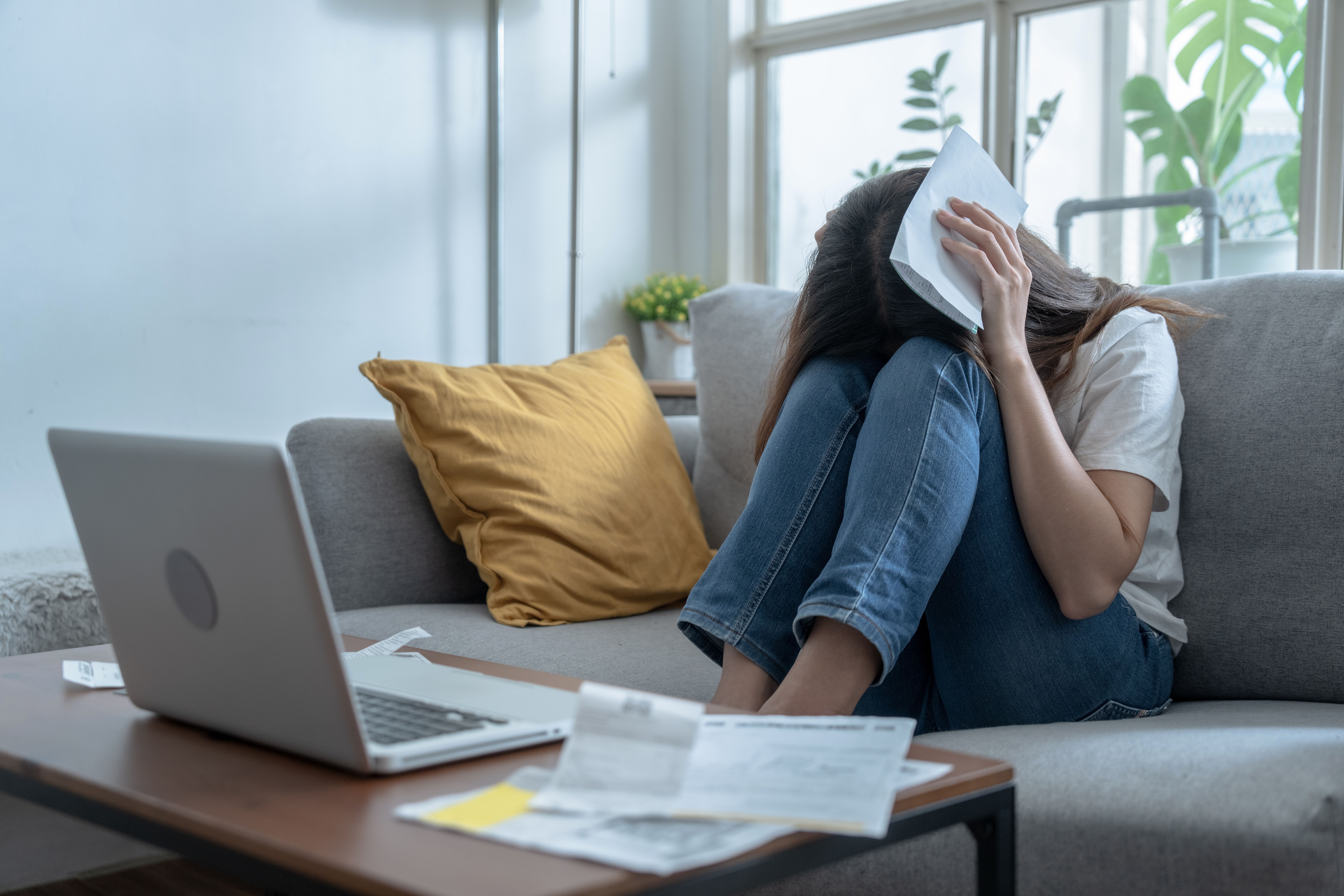 Young Asian woman stressed when she saw the expenses on her bill, Financial problems, Indebtedness, Lose a job.
