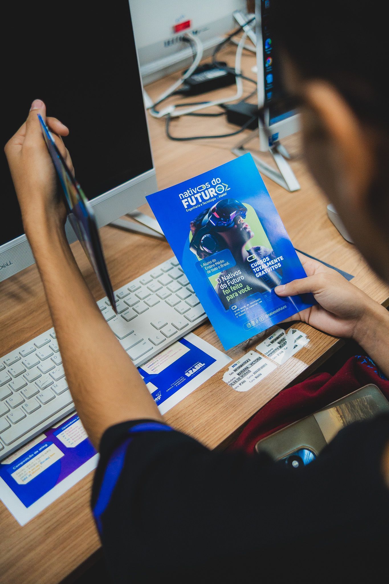 Jovem seguro um manual no qual está escrito "Nativos do Futuro"