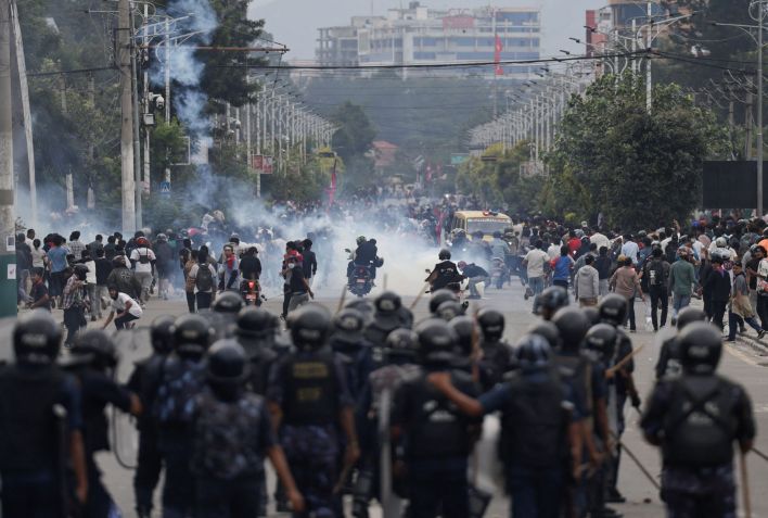 Policiais de choque perseguem manifestantes na capital nepalesa durante o protesto de segunda-feira. • Navesh Chitrakar/Reuters via CNN Newsource