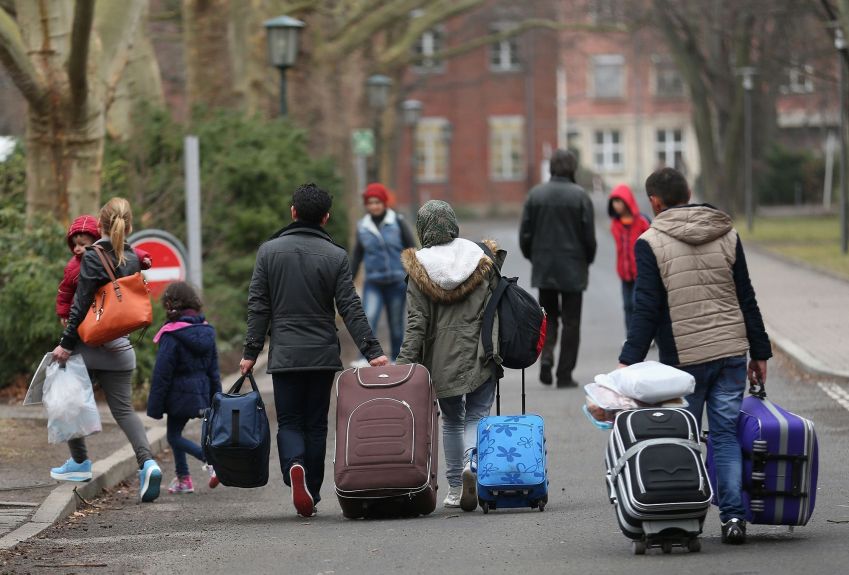 Pessoas puxando malas chegam a um escritório de registro de refugiados e migrantes que chegam a Berlim e buscam asilo, em 11 de março de 2015. • : Sean Gallup/Getty Images via CNN Newsource