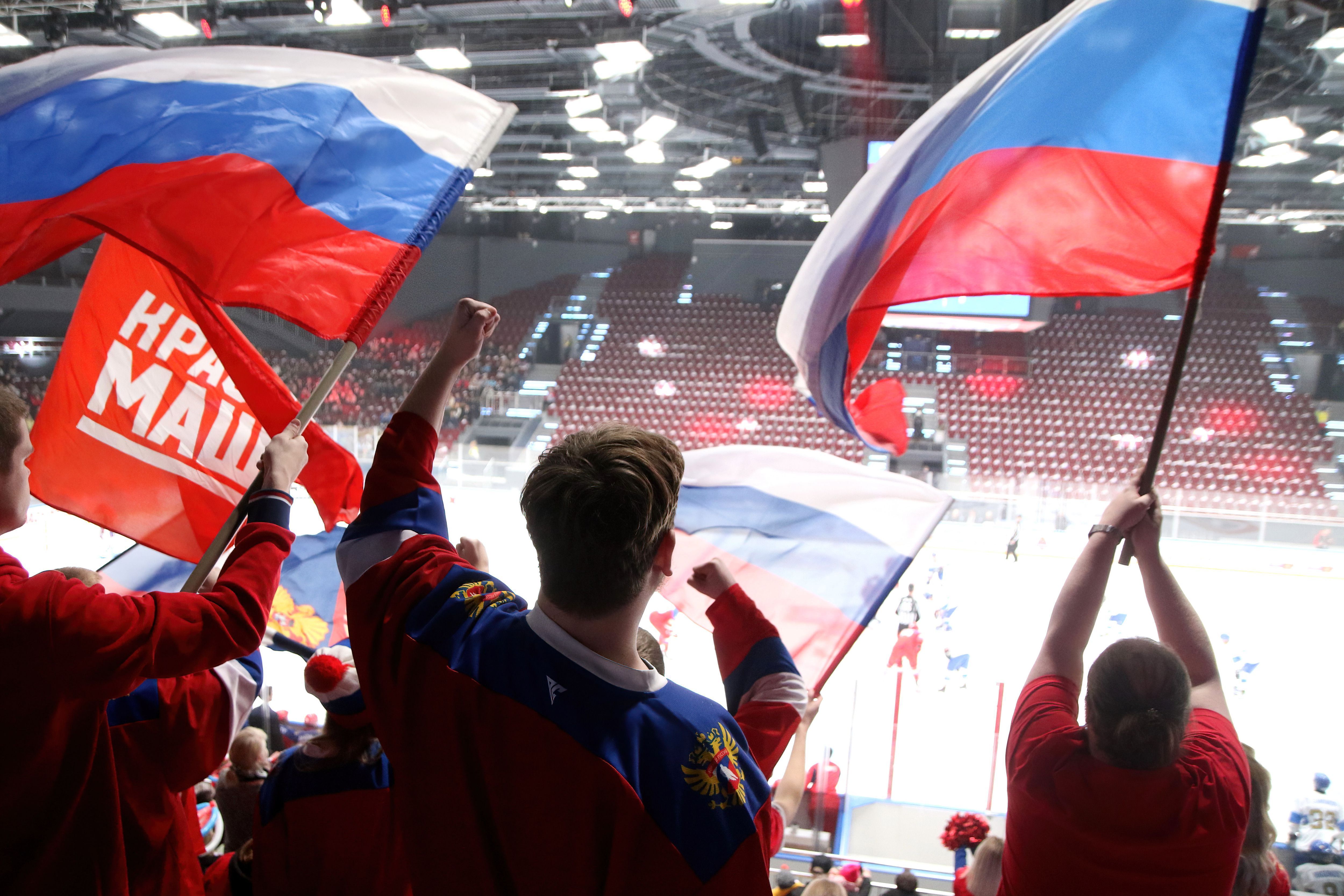 Torcedores russos com a bandeira do país durante jogo de hóquei no gelo