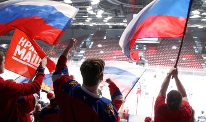 Torcedores russos com a bandeira do país durante jogo de hóquei no gelo