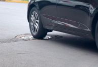 Estacionar o carro em cima de tampa de bueiro pode pesar no bolso; entenda