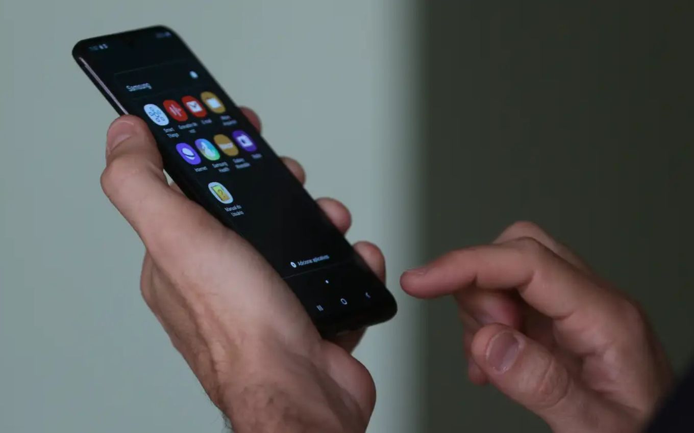 Uma pessoa segura celular em uma das mãos