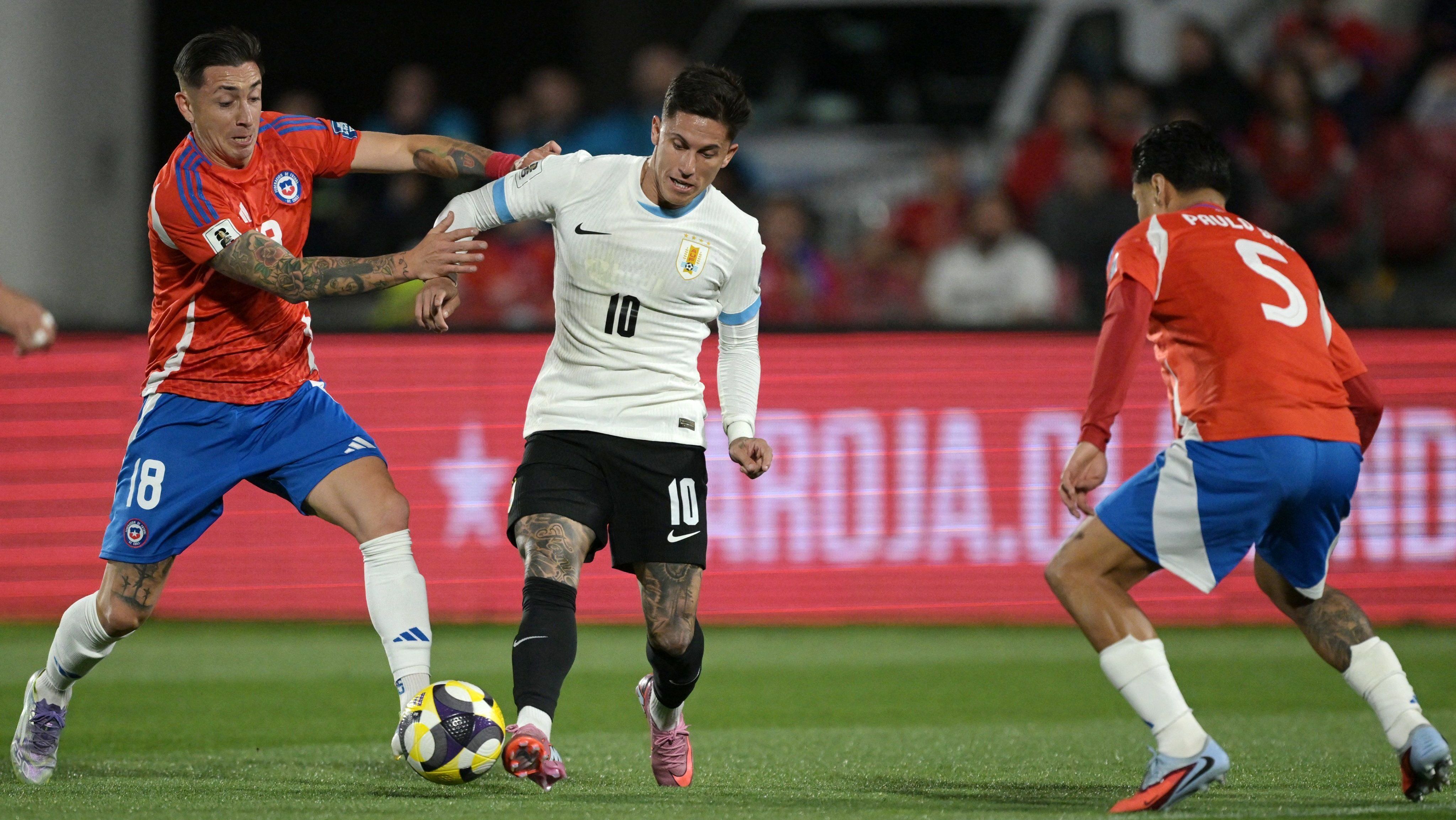 Disputa de bola na partida entre Chile e Uruguai, válida pelas Eliminatórias
