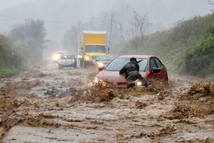 Um morador ajuda a liberar um carro que ficou preso em um trecho de estrada inundada nos arredores de Boone, Carolina do Norte, durante o furacão Helene