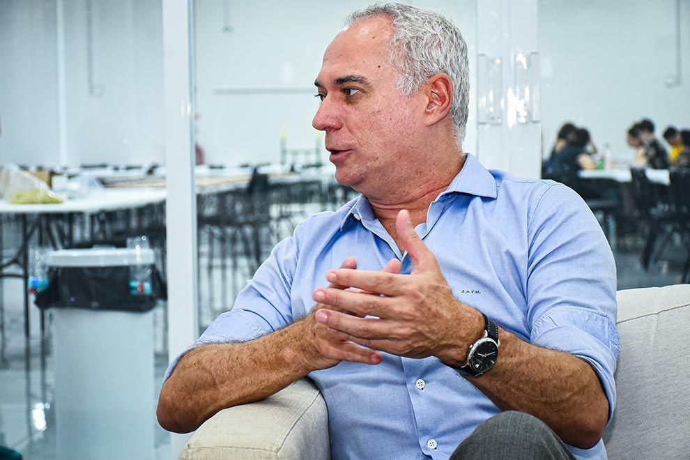 O diretor da Comvest, José Alves de Freitas Neto, está sentado e gesticulando durante uma conversa