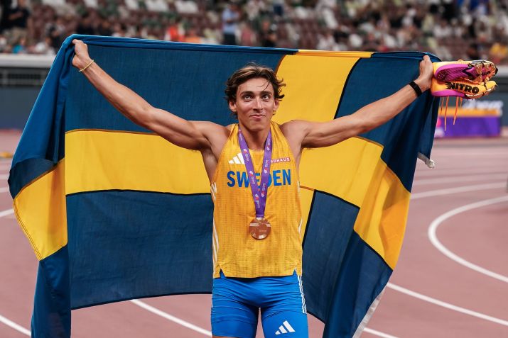 Armand Duplantis celebra a medalha de ouro e o recorde com a bandeira da Suécia • Daniela Porcelli/Getty Images