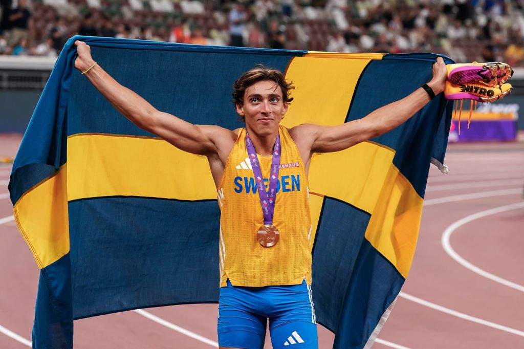 Armand Duplantis celebra a medalha de ouro e o recorde com a bandeira da Suécia