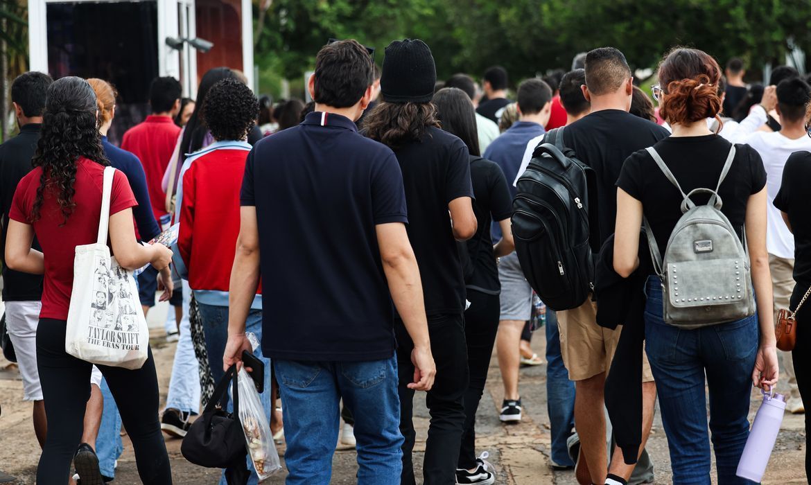 Grupo de jovem caminham na calçada