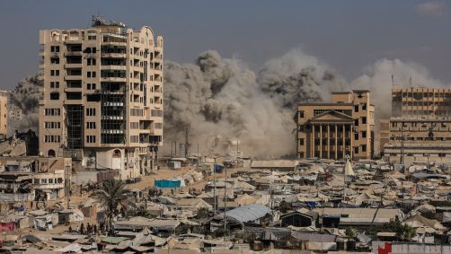 Fumaça sobe enquanto um prédio residencial desaba após ataque aéreo israelense na Cidade de Gaza