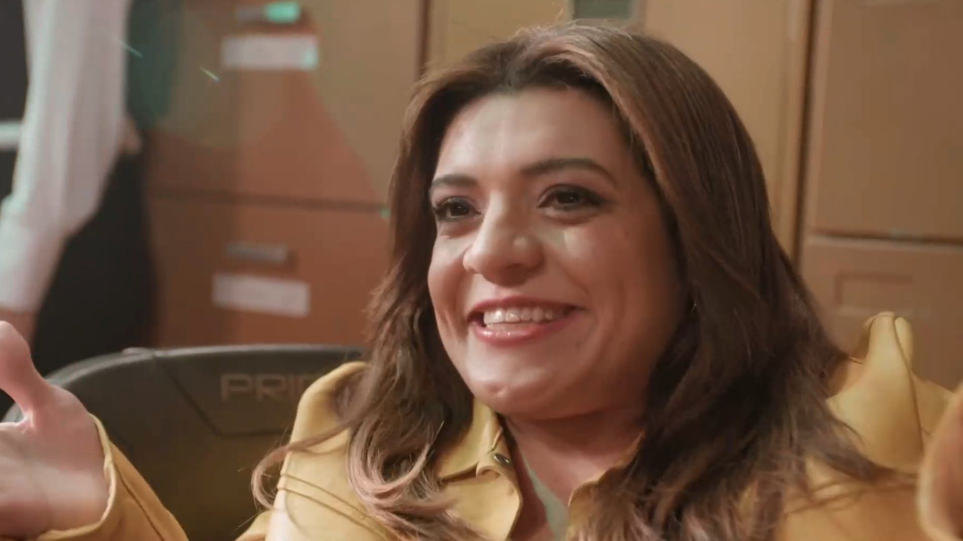 influenciadora e apresentadora Pequena Lô está sorridente e usa casaco amarelo