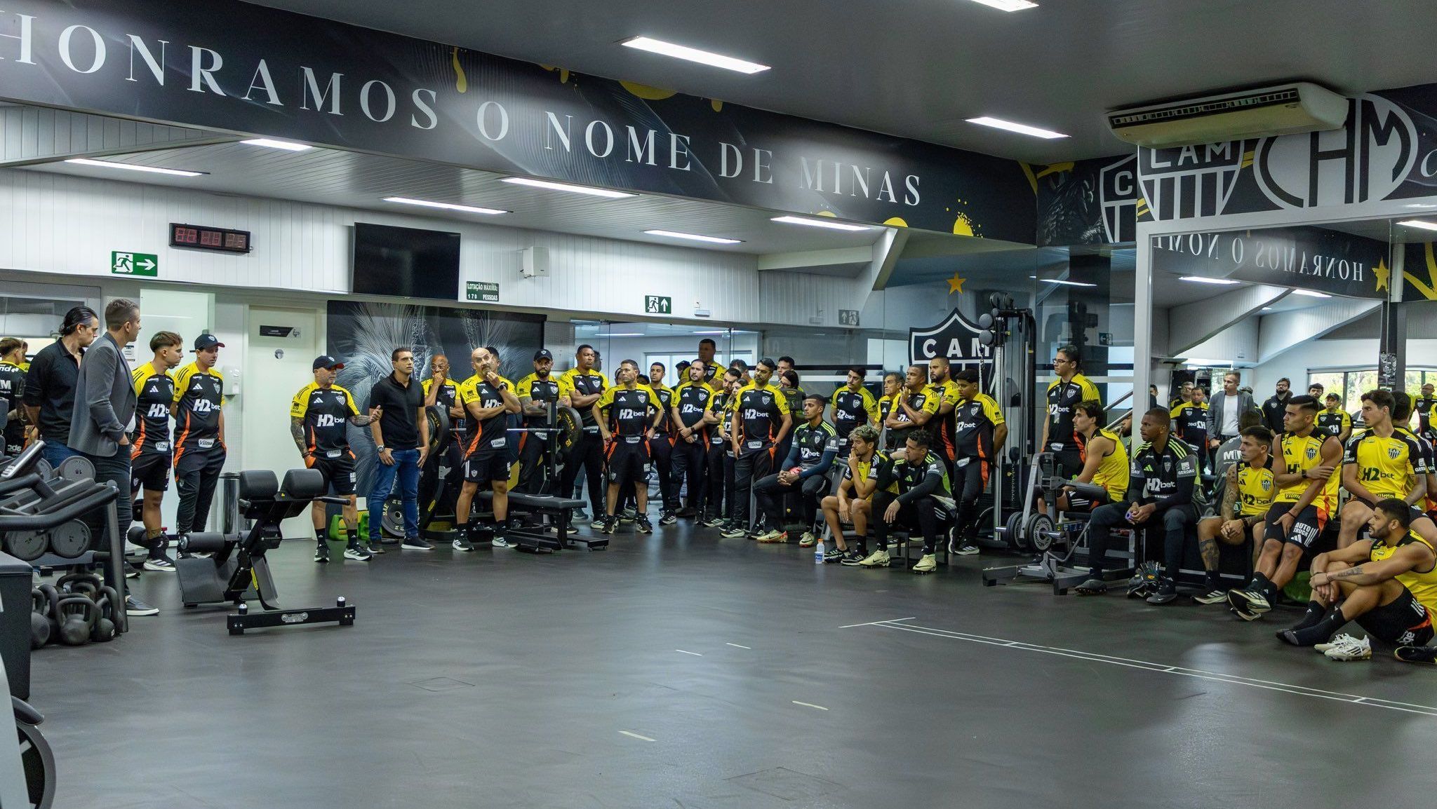 Jorge Sampaoli (de boné, próximo à televisão) conversa com elenco, funcionários e dirigentes do Atlético-MG em seu primeiro treino após o retorno