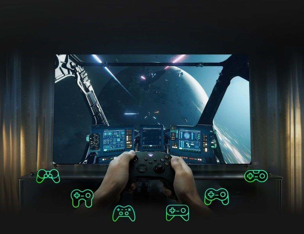Captura-de-tela-com-mãos-de-uma-pessoa-segurando-um-controle-de-videogame-na-frente-de-uma-tv-com-simbolos-de-games