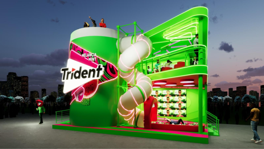 No estande, o consumidor é convidado a entrar literalmente no universo da marca: aroma de menta, Trident X Senses gigante, tobogã em formato de boca e cabine de GIFs para registro e compartilhamento. • Reprodução