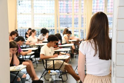 Estudantes sentados em uma sala de aula prestando vestibular