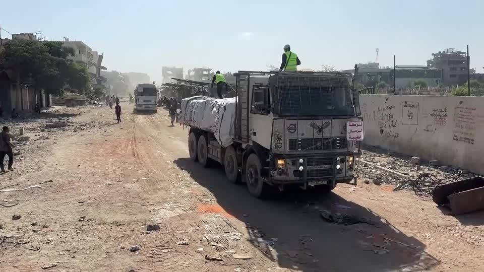 Caminhões de ajuda humanitária passam por Khan Younis, em Gaza