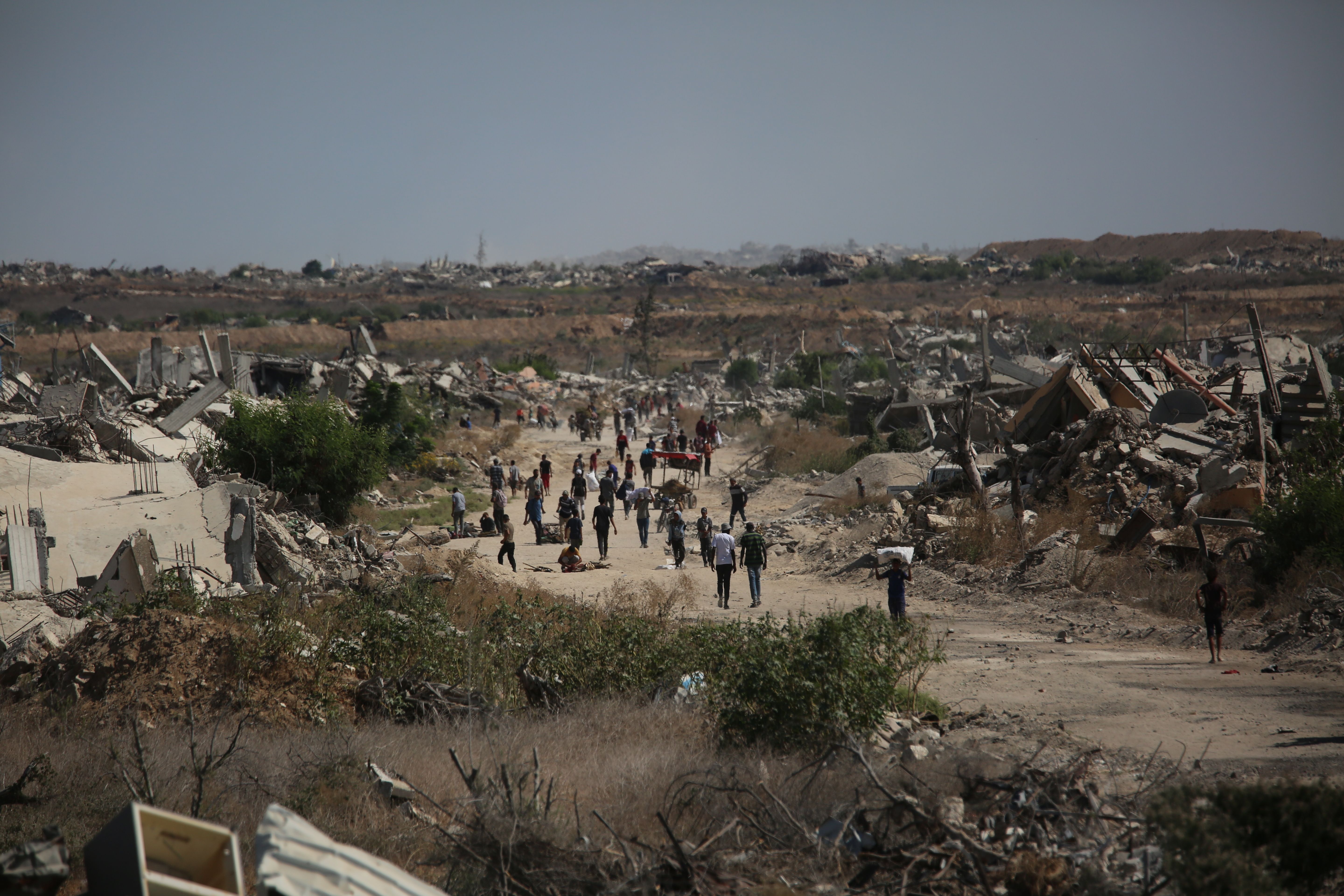 Palestinos, incluindo crianças, caminham rumo ao norte da Faixa de Gaza, em Deir Al-Balah, após início do cessar-fogo.