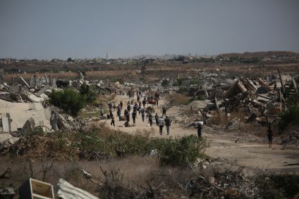 Palestinos, incluindo crianças, caminham rumo ao norte da Faixa de Gaza, em Deir Al-Balah, após início do cessar-fogo.