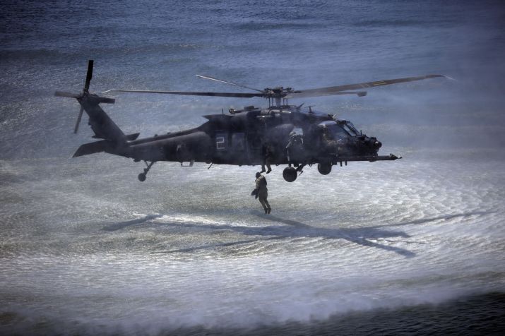 Membro da Marinha dos EUA salta a partir de um helicóptero pilotado pelo 160º Regimento de Aviação de Operações Especiais do Exército dos EUA • Luke Sharrett/Getty Images