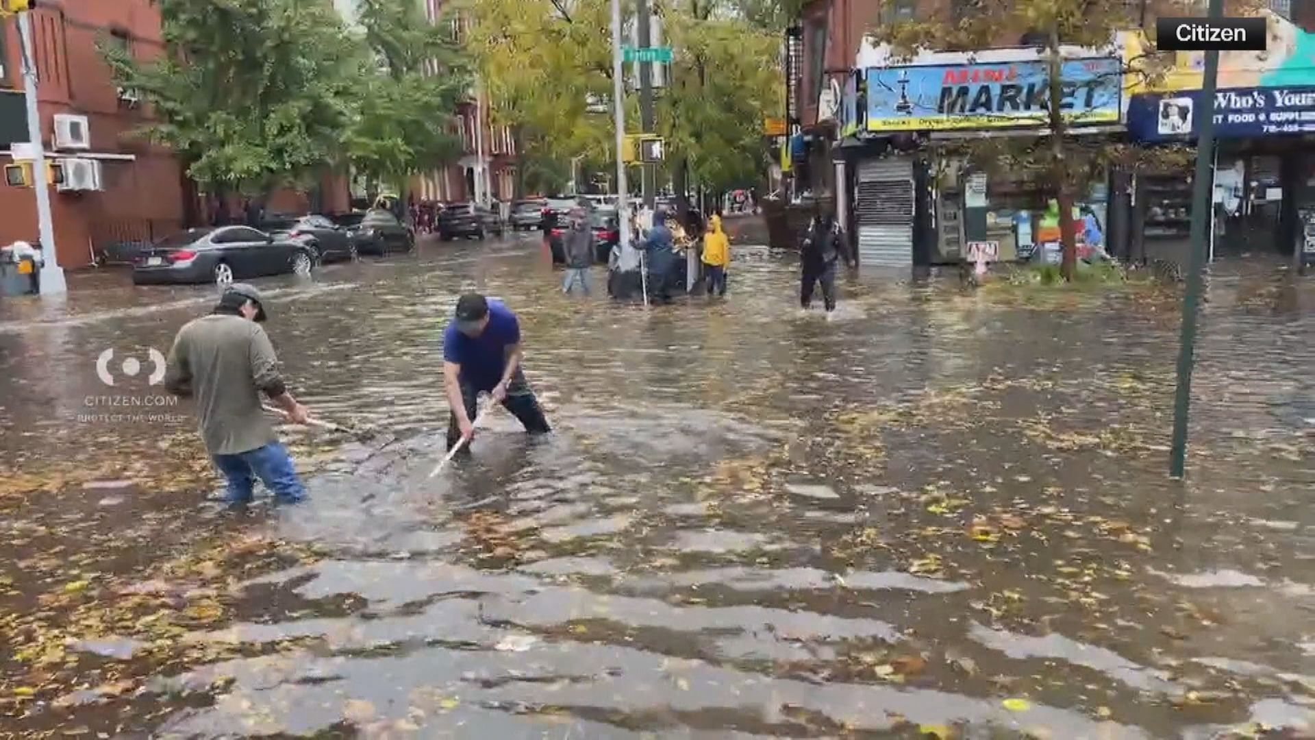 Veículos atravessando áreas alagadas enquanto fortes chuvas caem na cidade de Nova York