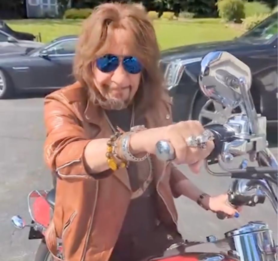 Motocicleta Harley e Escalade ao fundo da imagem