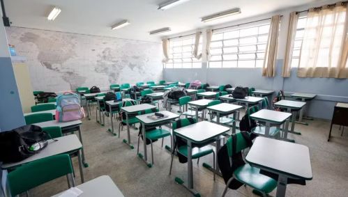 Foto mostra carteiras e cadeiras em sala de aula