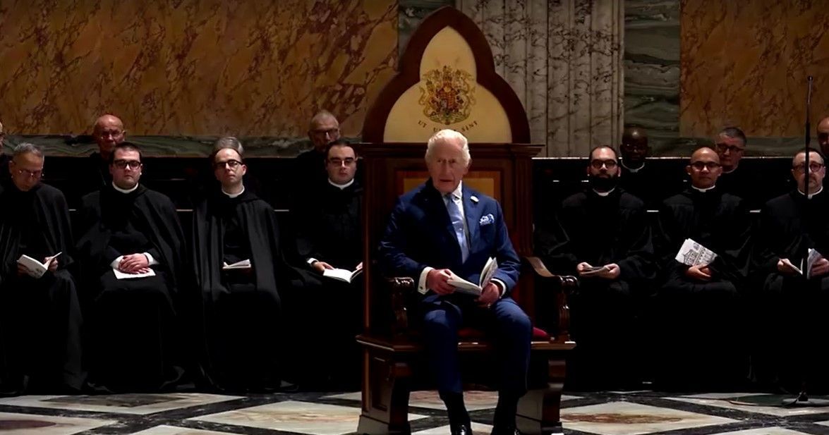O rei Charles III sentado na cadeira de madeira dedicada aos monarcas na Basílica de São Paulo Extramuros • AGENCY POOL / VATICAN MEDIA