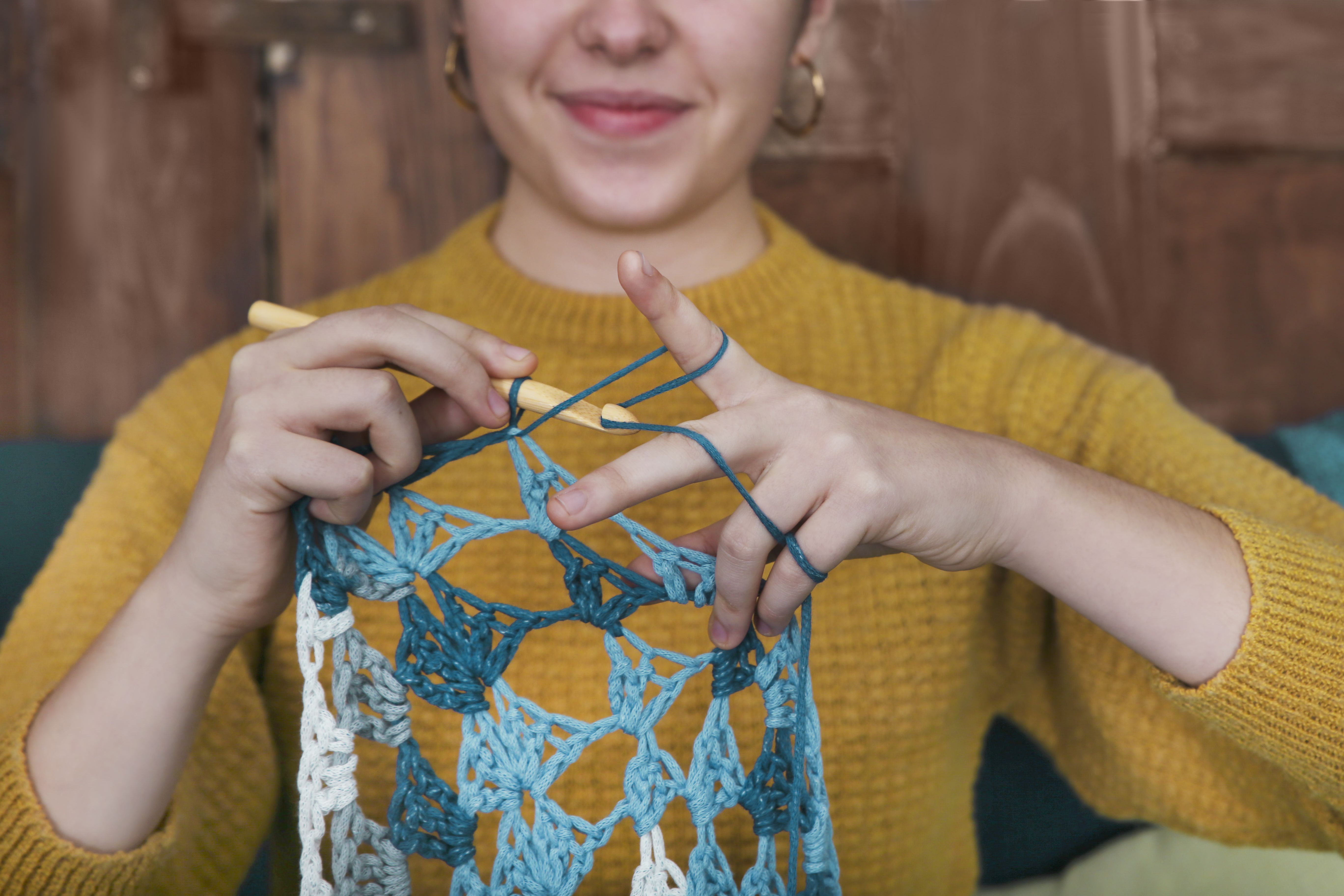 Young woman chrocheting doily, close-up