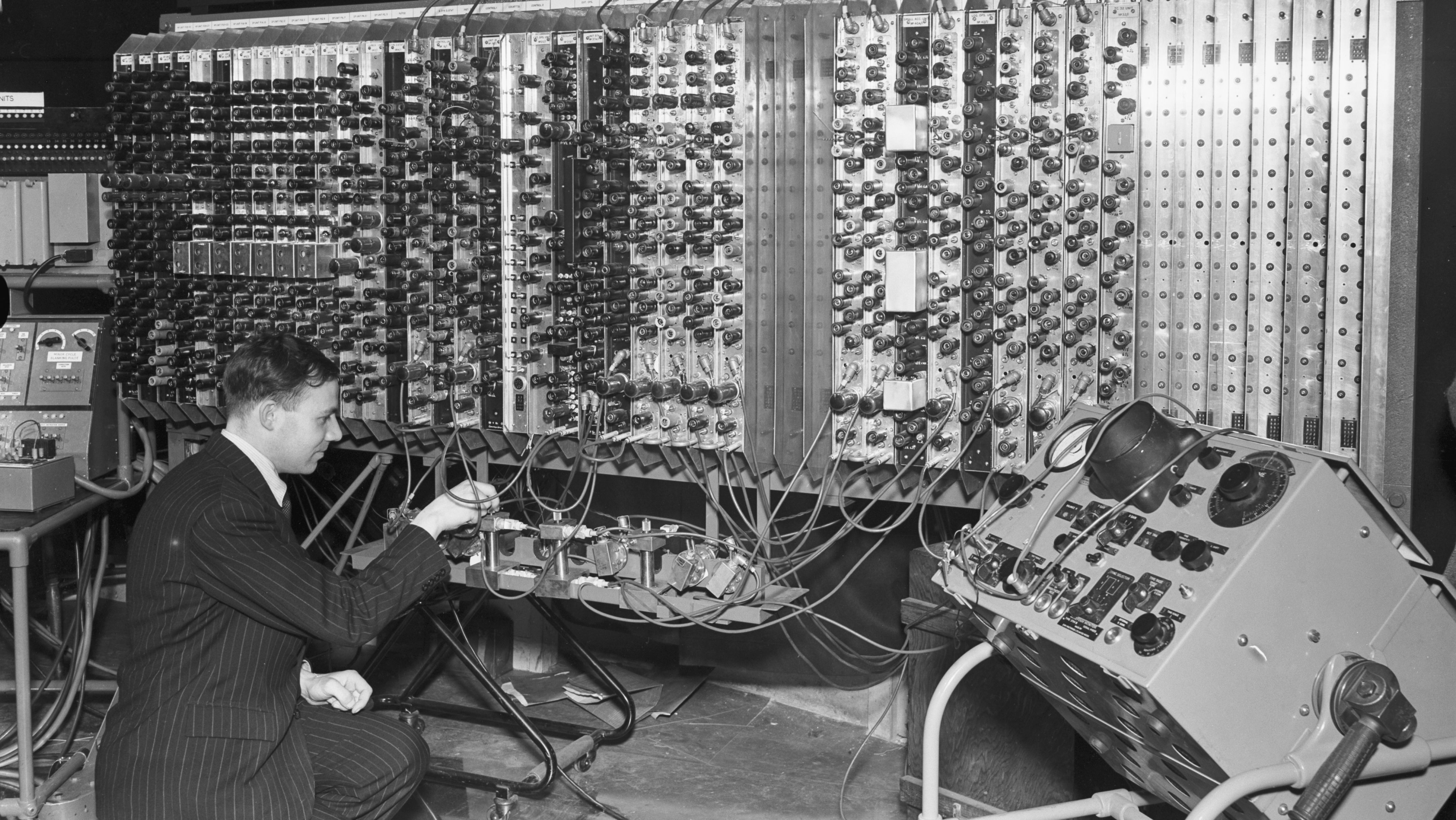 Engenheiro eletrônico Edward Newman inspecionando o protótipo do Automatic Computing Engine (ACE), em 1950: um dos primeiros computadores construídos na Grã-Bretanha, projetada por Alan Turing em 1947