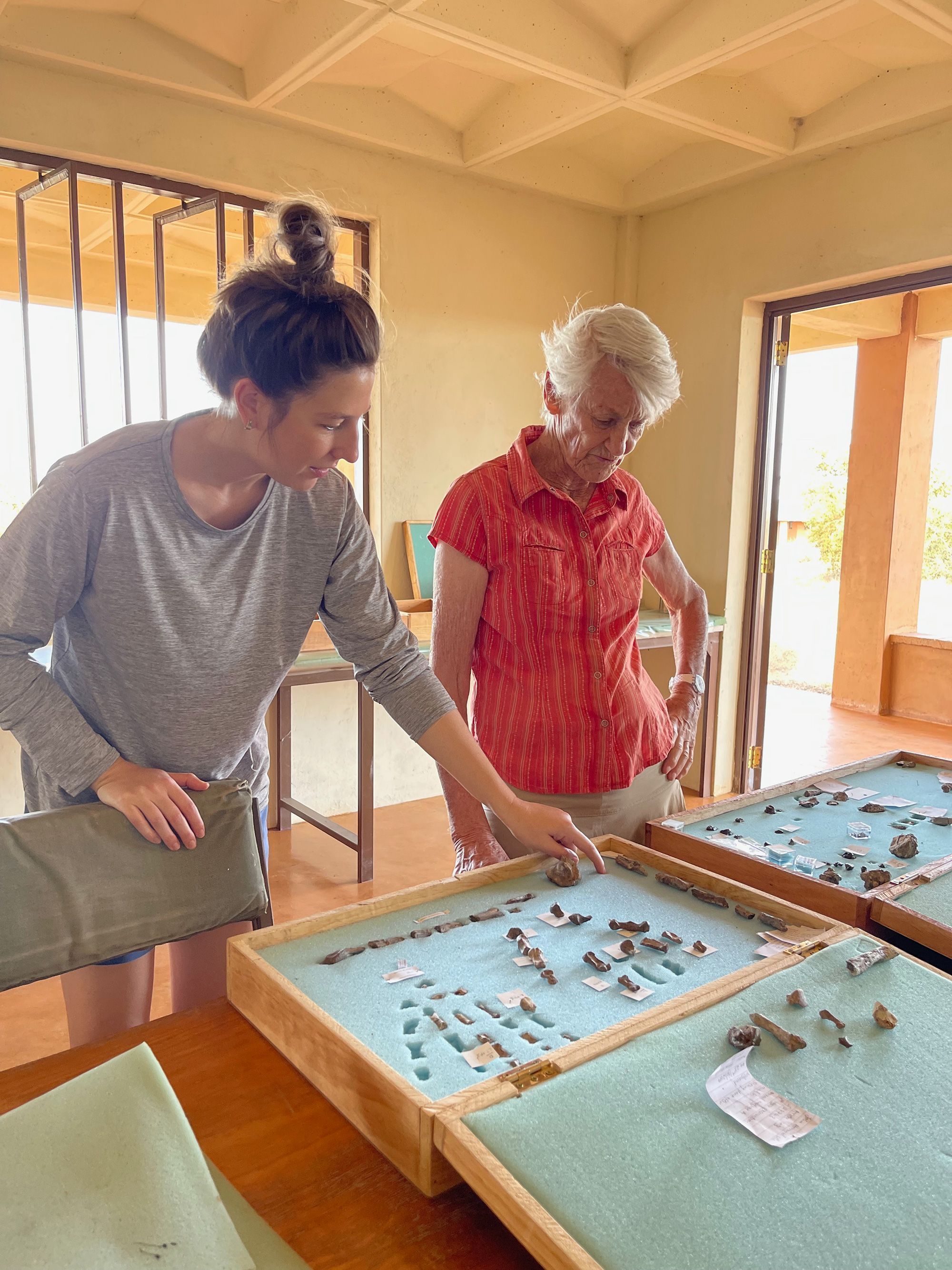As paleoantropólogas Carrie Mongle (à esquerda) e Meave Leakey, filha de Louis Leakey e Mary Leakey, que encontraram o primeiro fóssil de P. boisei, discutem os novos fósseis de mãos de P. boisei na estação de pesquisa do Instituto da Bacia de Turkana em Ileret, Quênia • Louise Leakey via CNN Newsource