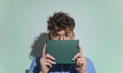 Man Covering Face With Book
