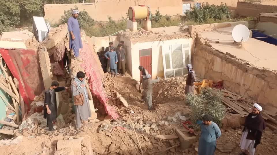 Pessoas fazendo buscas em meio aos entulhos de casa destruída pelo terremoto