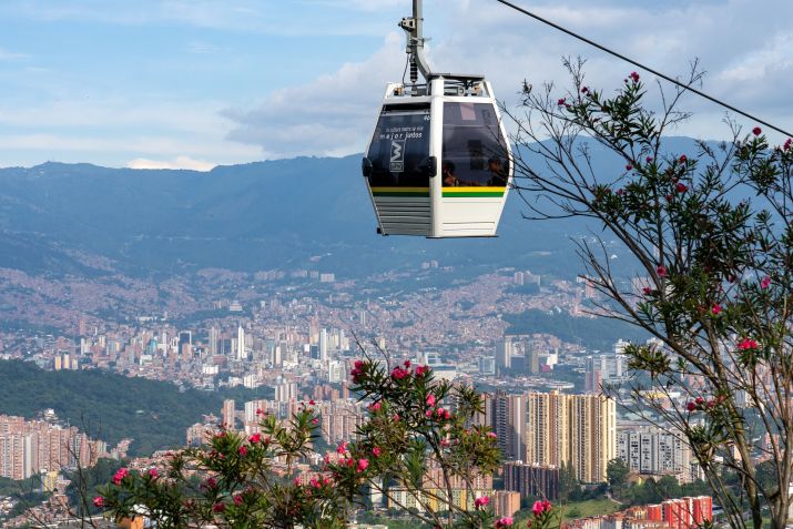 Uma gôndola do sistema Metrocable de Medellín com o centro de Medellín, Colômbia, ao fundo. • Jon G. Fuller/VW Pics/Universal Images Group via Getty Images