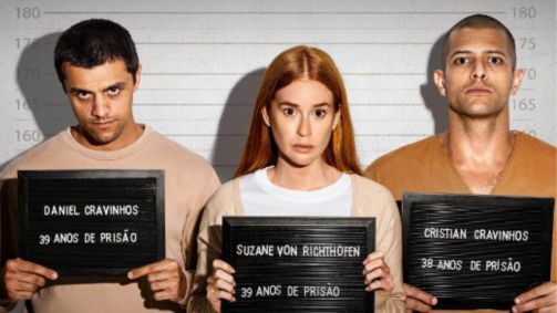 A atriz Marina Ruy Barbosa interpreta Suzane von Richthofen. Ela segura uma placa e veste roupa de presidiária