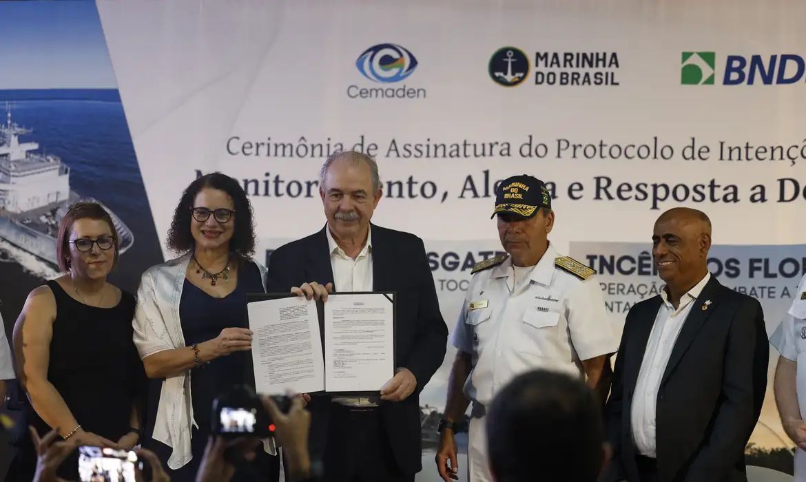 Representantes de BNDES, Marinha e Cemaden mostram documento de parceria assinado